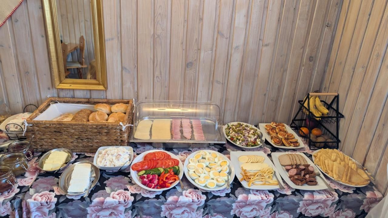 Stół w drewnianej jadalni z pieczywem, jajkami, warzywami i serami