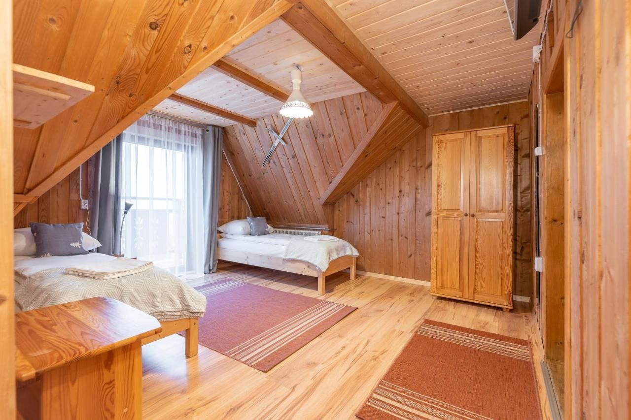 Duży pokój na poddaszu z trzema łóżkami i wyjściem na balkon